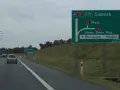 Zielony znak drogowy z kierunkami: Gdańsk, Płock, Nowy Dwór Maz., Warszawa-Modlin.