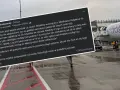 Samolot Wizz Air na płycie lotniska, schody ewakuacyjne i fragment wpisu o overbookingu.
