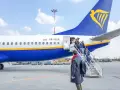 Pasażerowie wsiadają po schodkach do samolotu Ryanair.