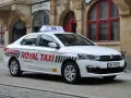 Biała taksówka Royal Taxi z numerem 260 na tle zabytkowej kamienicy we Wrocławiu.