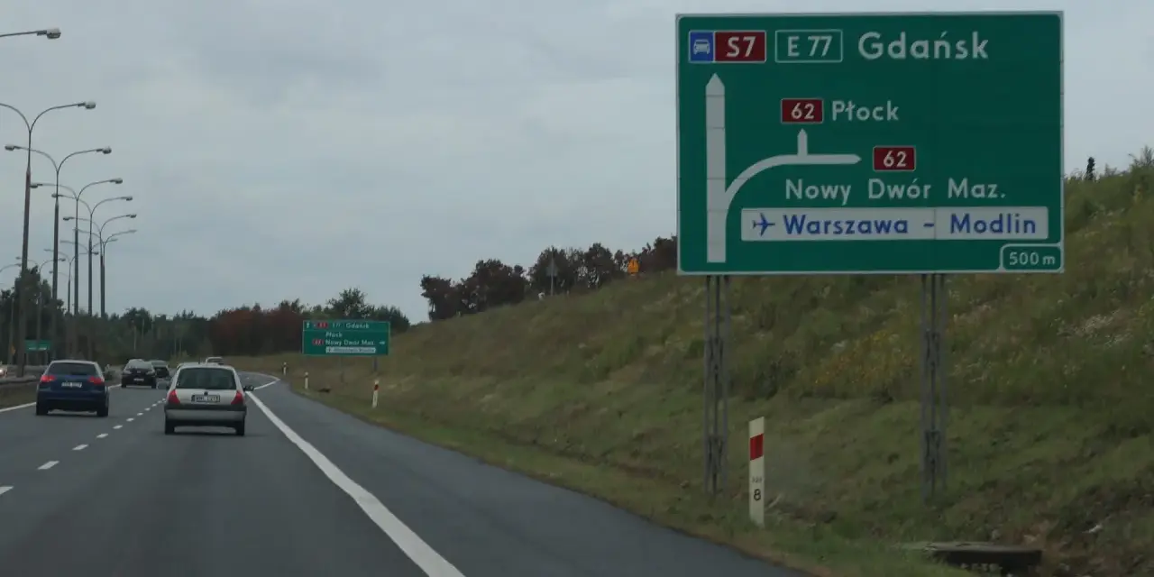 Zielony znak drogowy z kierunkami: Gdańsk, Płock, Nowy Dwór Maz., Warszawa-Modlin.