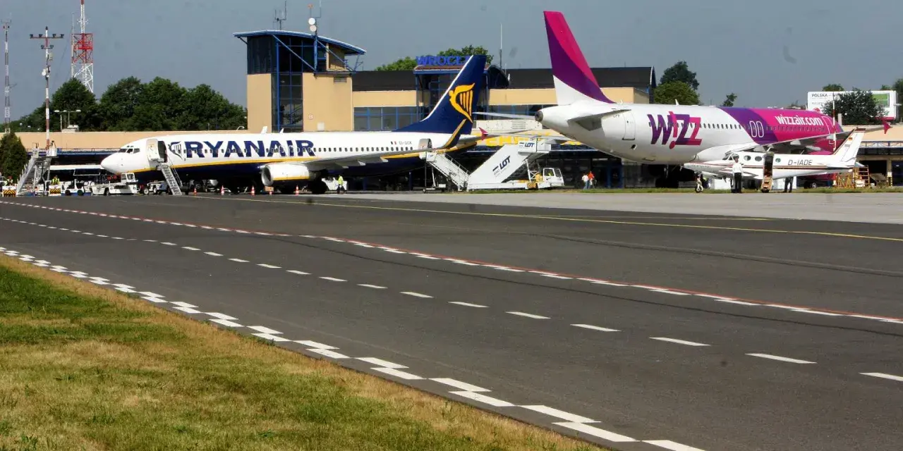 Dwa samoloty, Ryanair i Wizz Air, stojące na płycie lotniska.