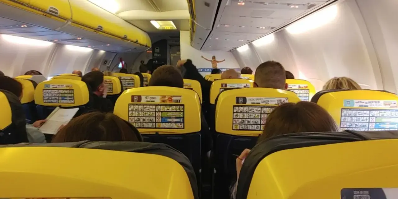 Widok z wnętrza samolotu Ryanair z żółtymi siedzeniami i pasażerami.