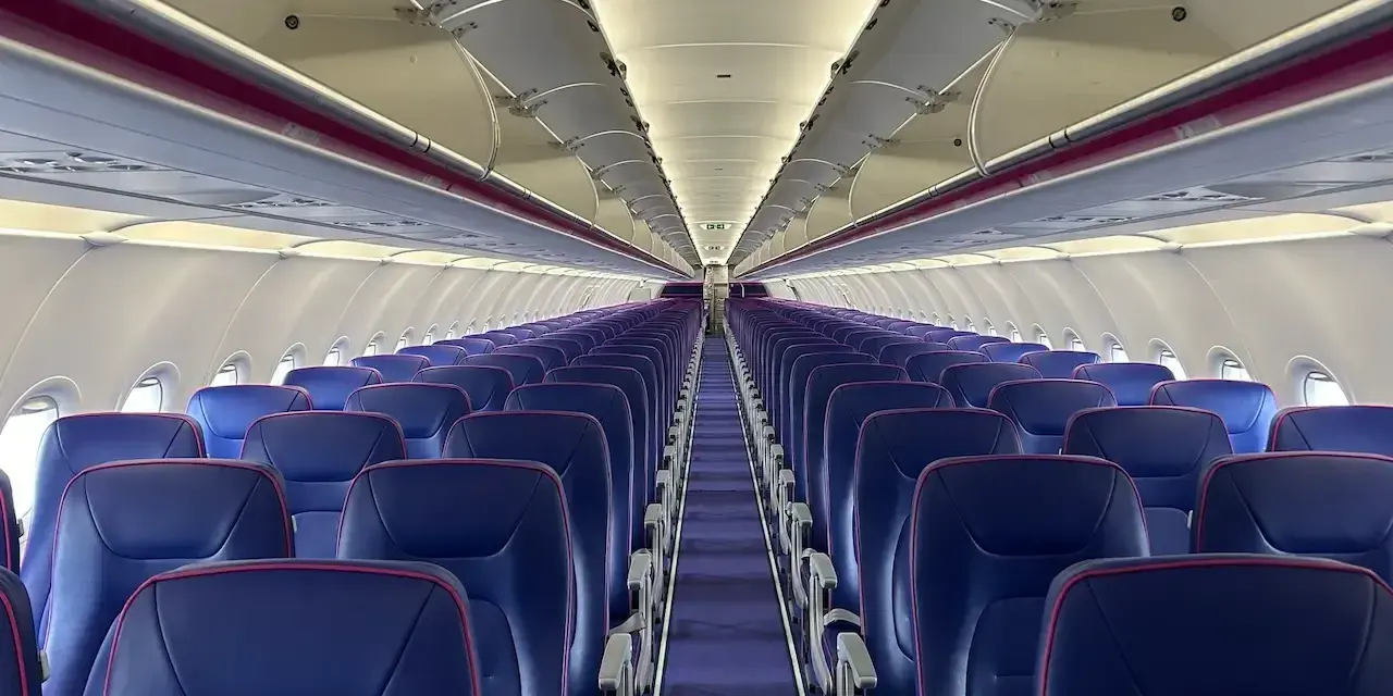 Puste fioletowe siedzenia w samolocie Wizz Air.