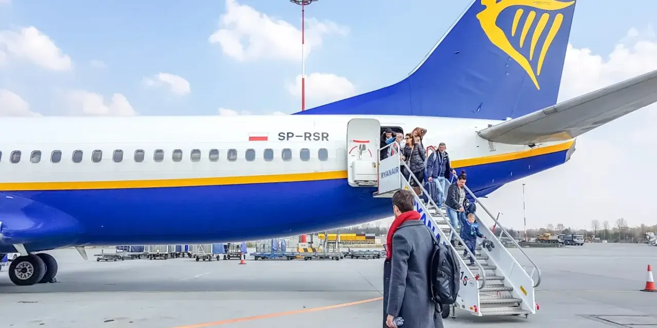 Pasażerowie wsiadają po schodkach do samolotu Ryanair.