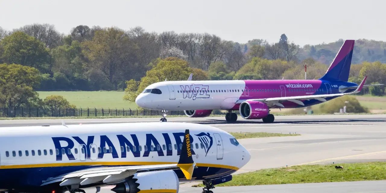 Samolot Ryanair na pierwszym planie, w tle samolot Wizz Air na pasie startowym.