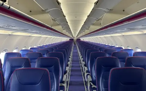 Puste fioletowe siedzenia w samolocie Wizz Air.