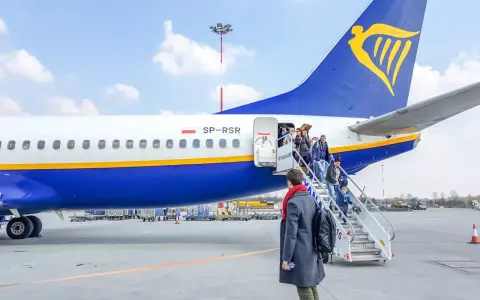 Pasażerowie wsiadają po schodkach do samolotu Ryanair.