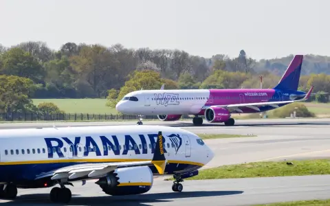 Samolot Ryanair na pierwszym planie, w tle samolot Wizz Air na pasie startowym.