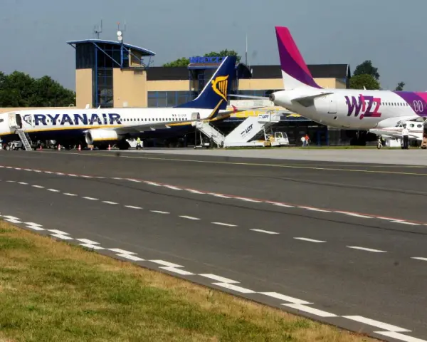 Dwa samoloty, Ryanair i Wizz Air, stojące na płycie lotniska.