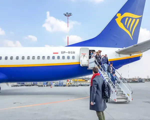 Pasażerowie wsiadają po schodkach do samolotu Ryanair.