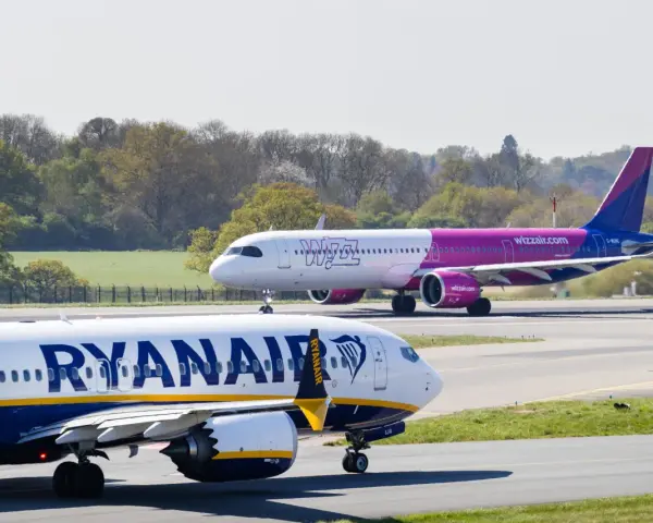 Samolot Ryanair na pierwszym planie, w tle samolot Wizz Air na pasie startowym.