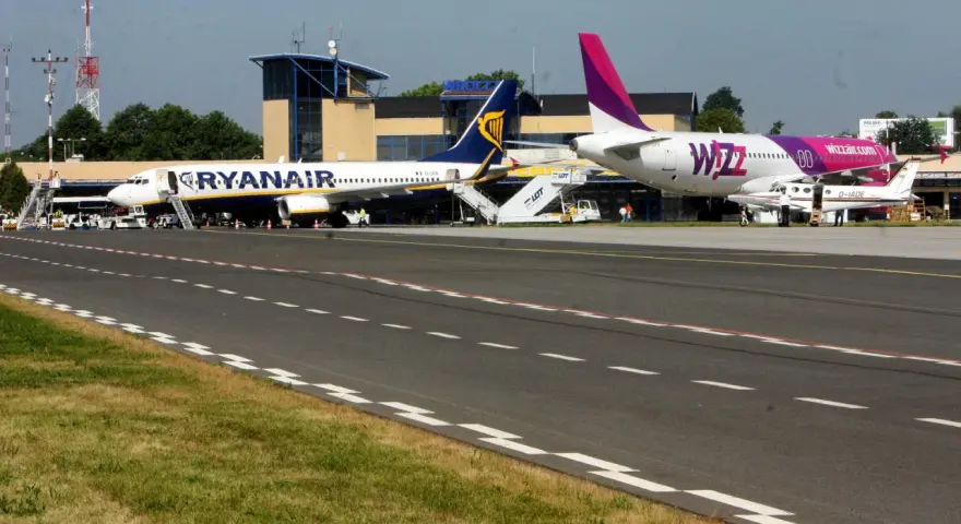 Dwa samoloty, Ryanair i Wizz Air, stojące na płycie lotniska.