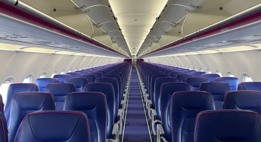 Puste fioletowe siedzenia w samolocie Wizz Air.