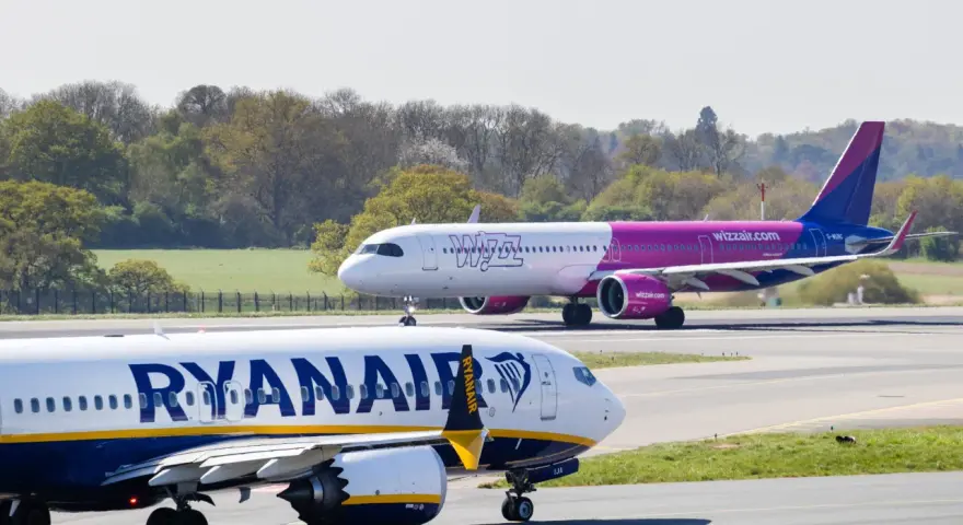 Samolot Ryanair na pierwszym planie, w tle samolot Wizz Air na pasie startowym.